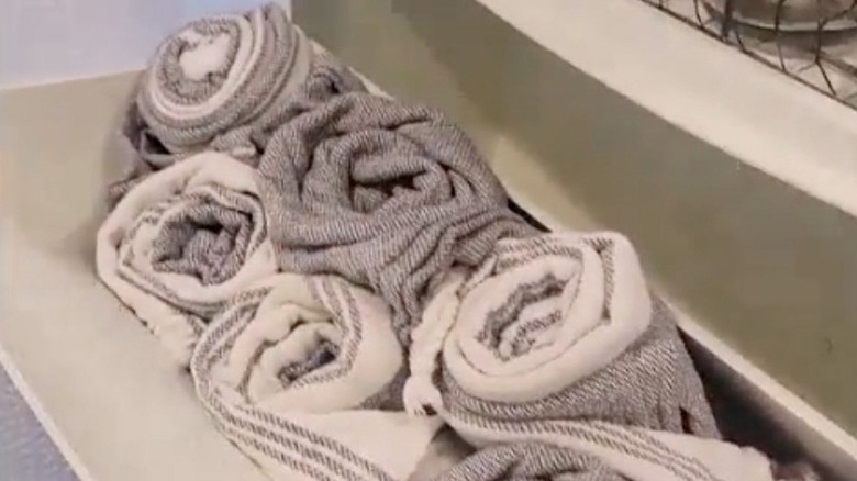 Towels being stored in a tilt out shoe cabinet