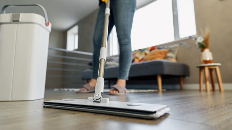 person mopping hardwood floor