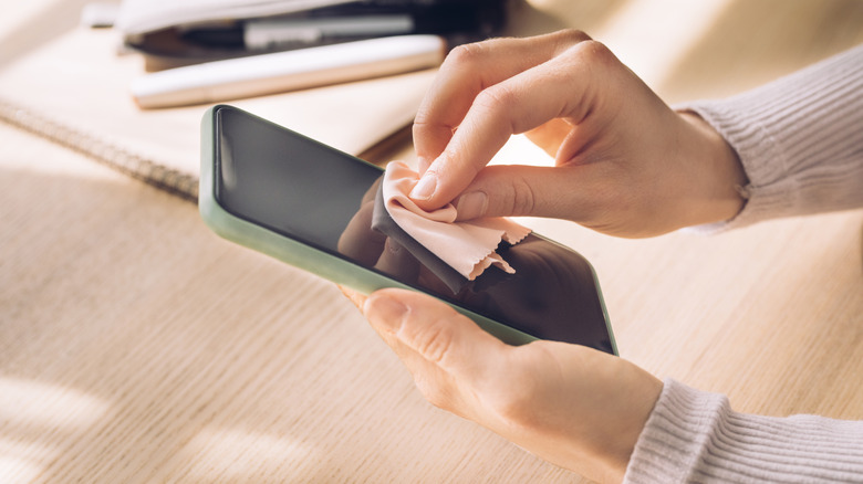 hands cleaning phone screen