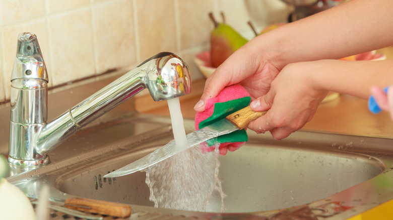 knife being washed in sink