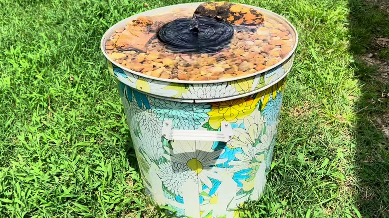 Floral-patterned trash can repurposed as a hummingbird bath