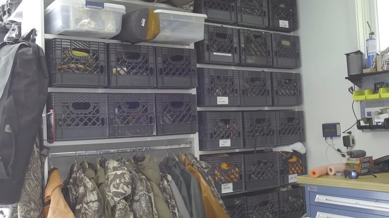 Garage shelving area with black plastic milk crafts aligned on shelves