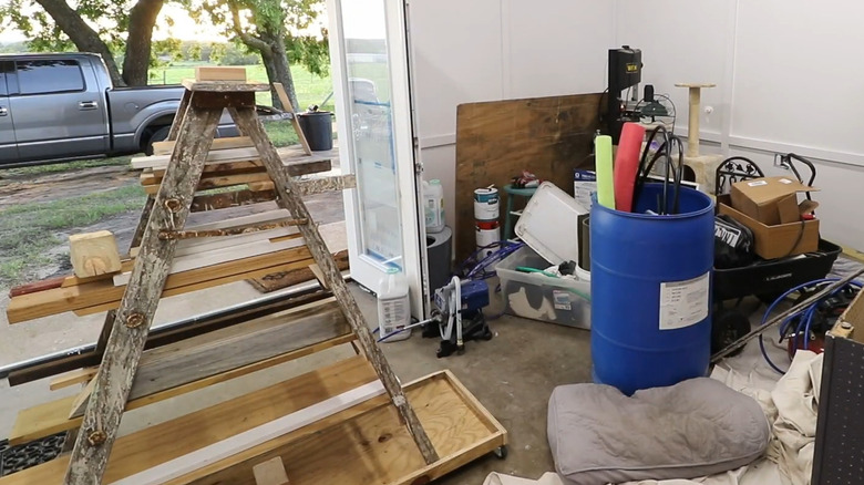 Old wooden step ladder sitting on a movable wood platform with wood scraps going across the rungs