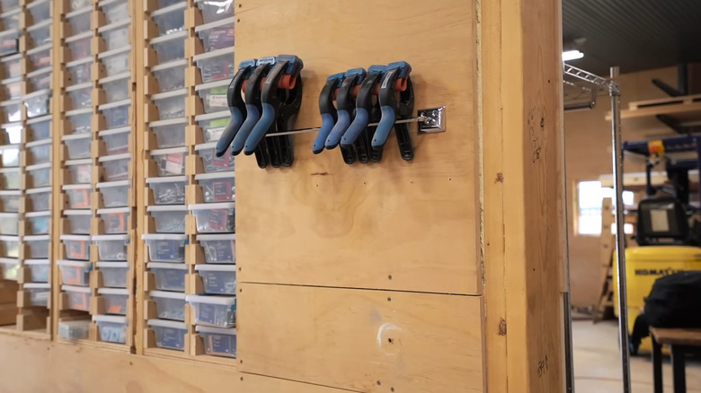 Thin metal towel bar with clamps balanced over it in a garage