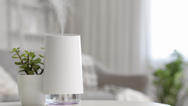 A white air humidifier releasing mist indoors