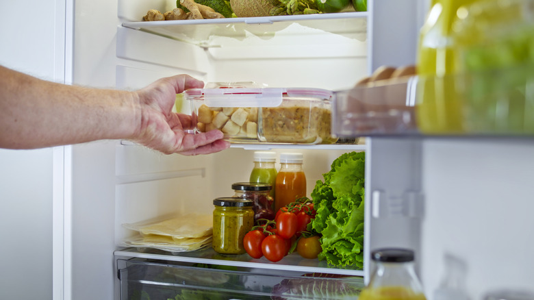 Hand removing food from fridge
