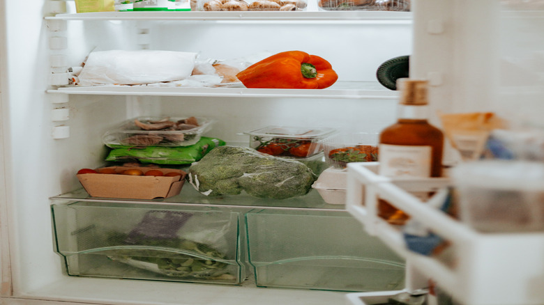 Yogurt and vegetables on refrigerator shelves