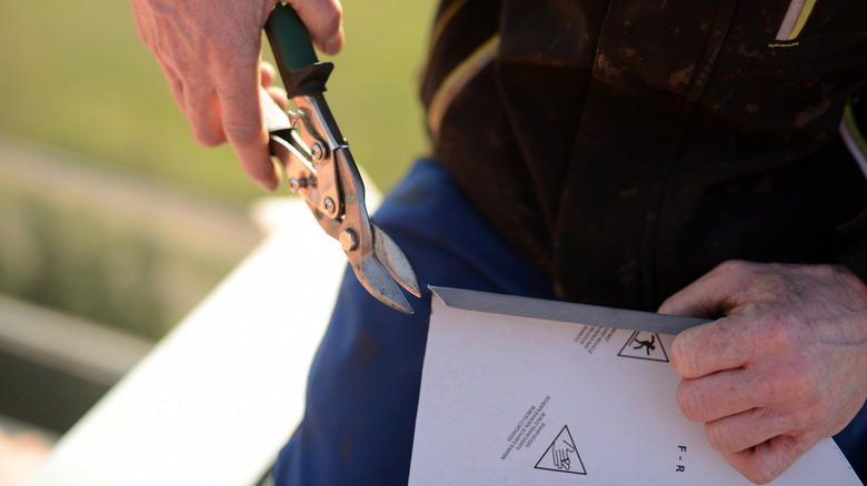 Person using metal snips to work through a package