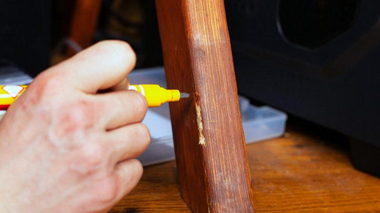 man using wood stain pen