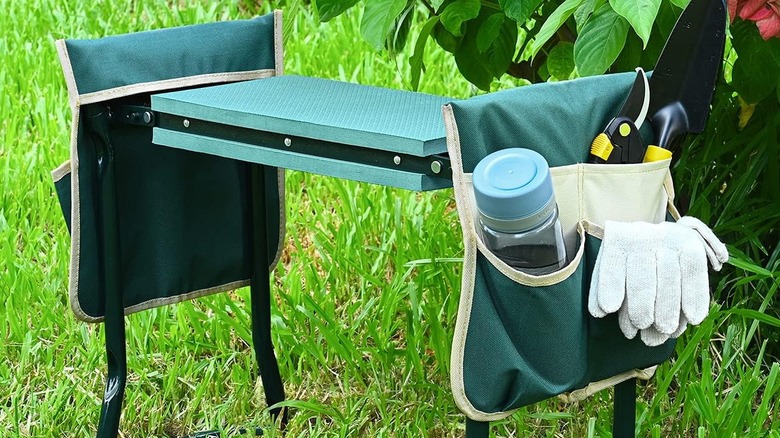 Gloves and a water bottle are stored in the pocket of a green KVR garden seat