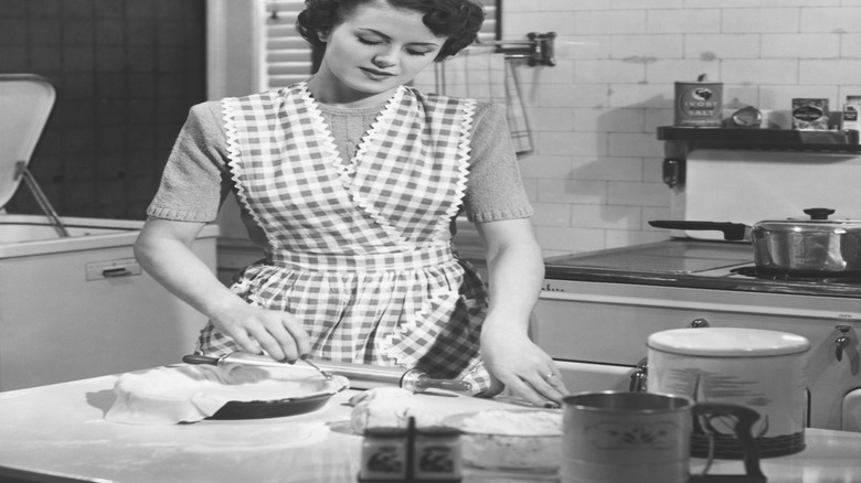 A vintage photo of a woman wearing a chequered apron
