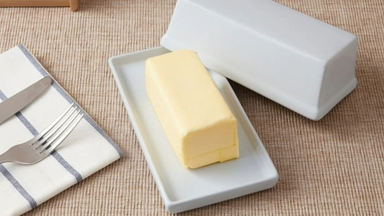 A simple white butter dish sitting on a counter