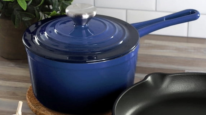 An enameled sauce pan with handle sitting on a counter