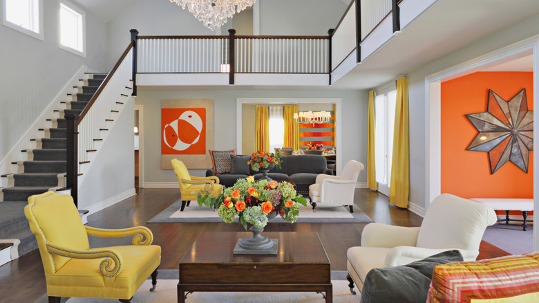 A living room with bold, orange geometric art on the while walls