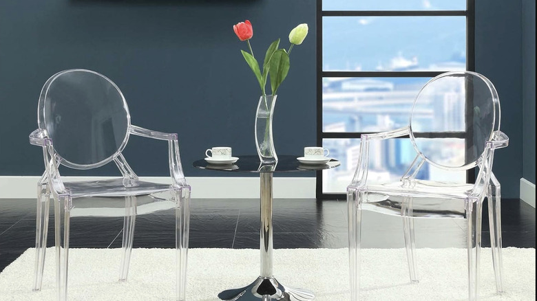 Two Modway acrylic dining chairs sit on a white rug against a deep blue wall