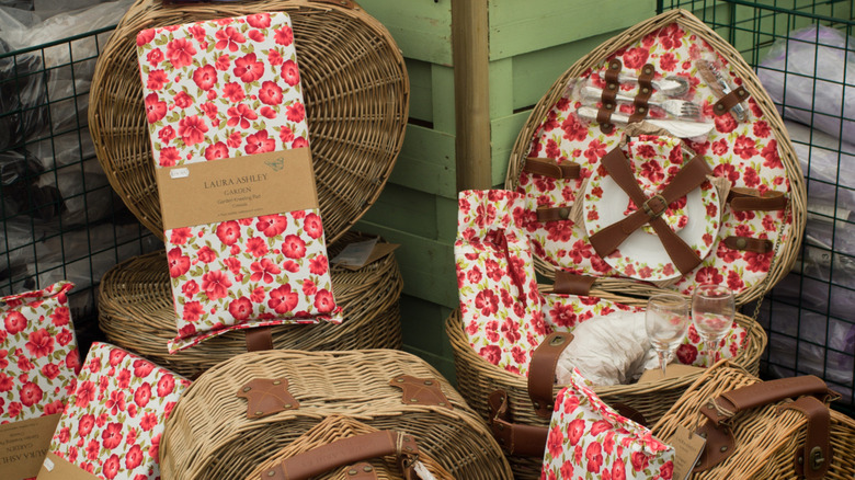 A collection of wicker baskets and picnic totes with Laura Ashley prints accenting them