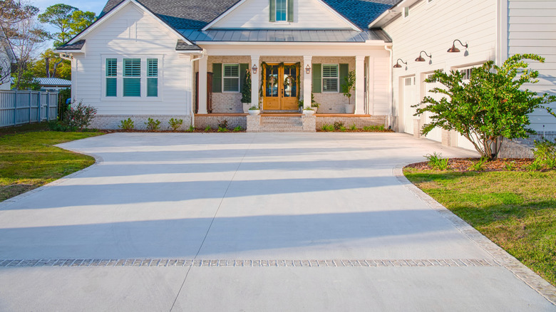 A driveway with clearly defined brick edges, separating large driveway pavers from the grass on either side