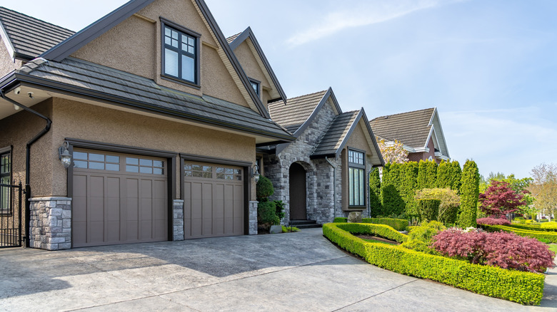 A modern home with a cement driveway and manicured lawn