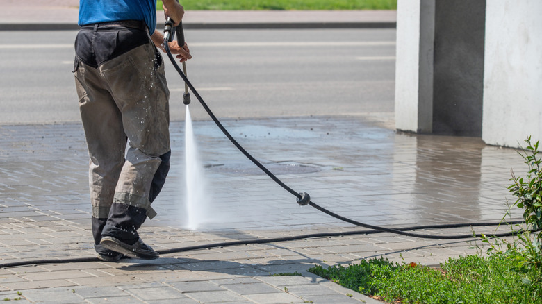A man cleaning a driveway with a pressure washer