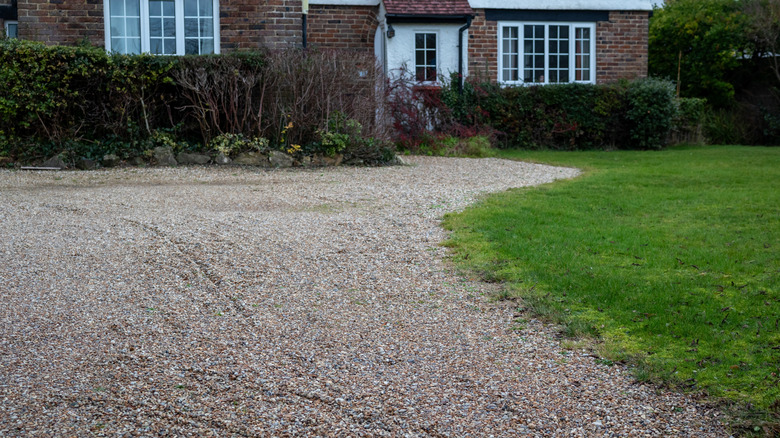 A gravel driveway in front of a house