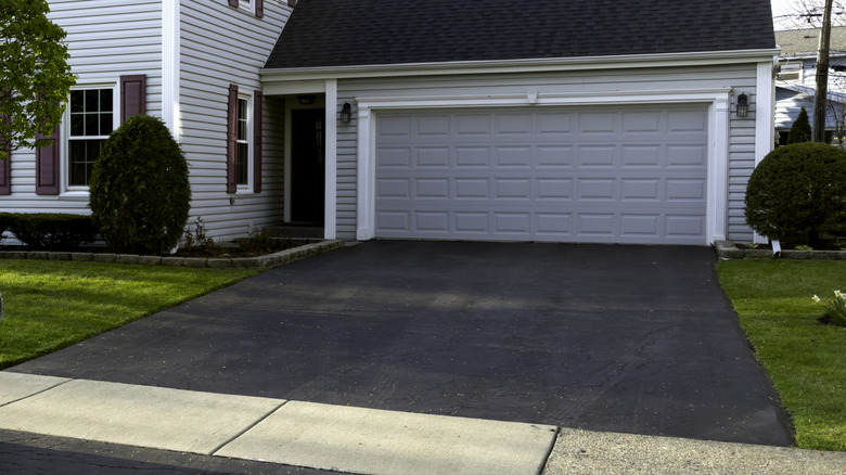 A two-car garage with asphalt driveway