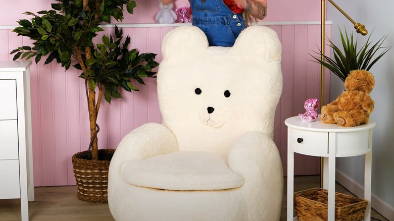 White plush teddy bear chair made from a tire in kids' room