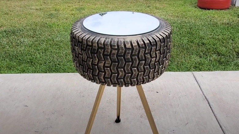 Tiny tire table with mirror top and gold tripod legs