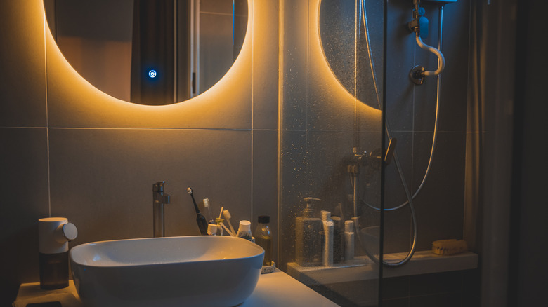 Bathroom with round backlit mirror
