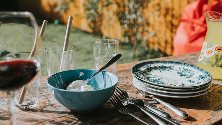 plates, bowl, and silverware on outdoor table