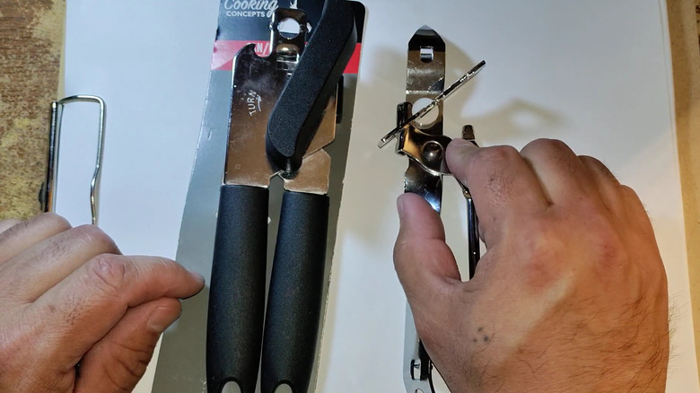 Man comparing two cheap can openers from dollar stores