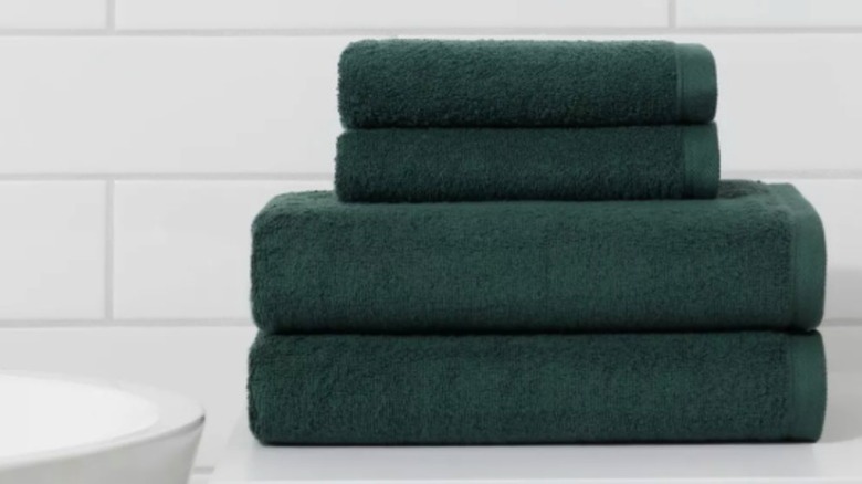 A stack of green towels in a bathroom