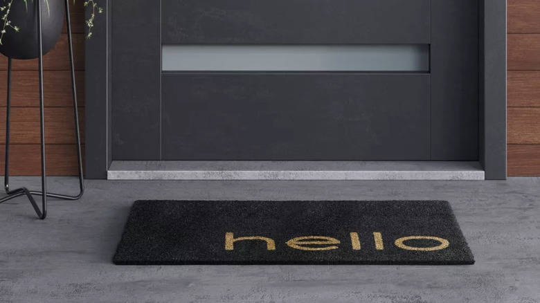 A black doormat with hello in a brown color