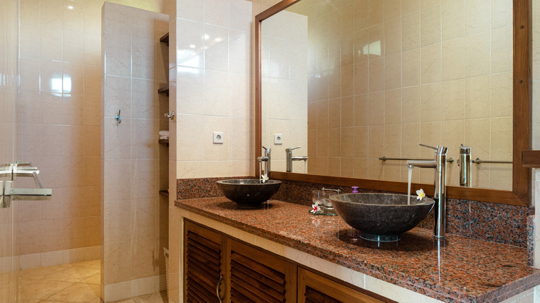 A bathroom with a wood-framed mirror