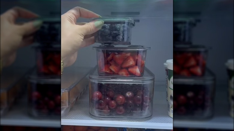 A stack of clear containers hold food in a fridge.