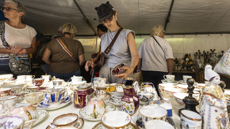 People shopping for glassware at an antique market