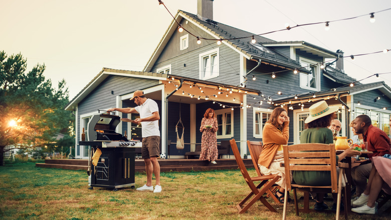 A garden party with friends sitting around a beautiful wooden furniture set