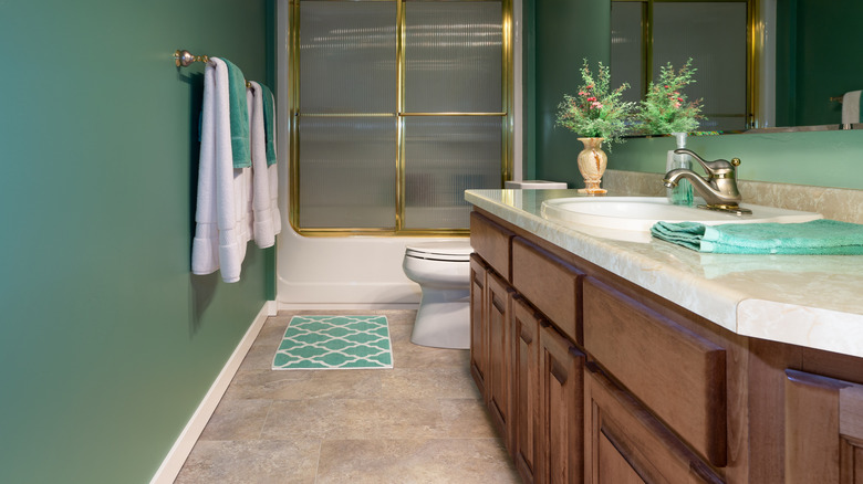 Modern bathroom with green and gold finishes