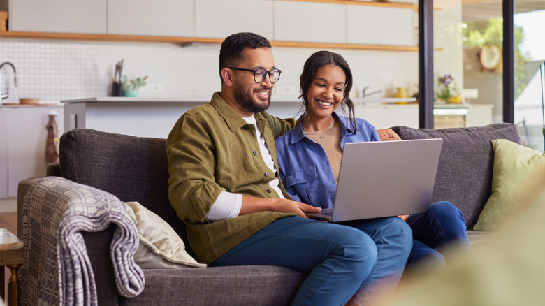A couple comparing prices online on a laptop