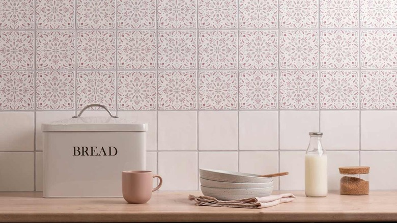 a dahlia patterned tile above two rows of plain tiles creates a stunning kitchen backsplash