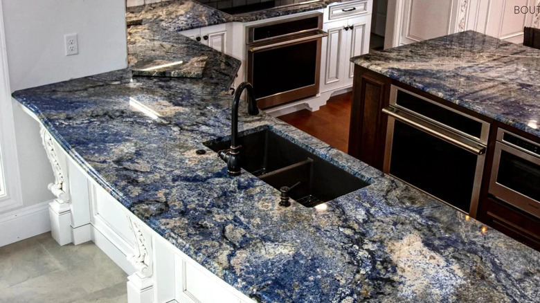 A staged kitchen with stone countertops with blue in them