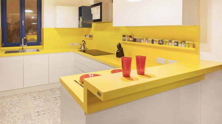 A mid-century modern style kitchen with a fresh and bold yellow countertop