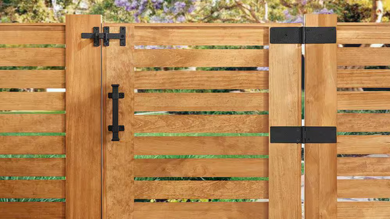 A wooden garden fence and gate built with black Everbilt hardware
