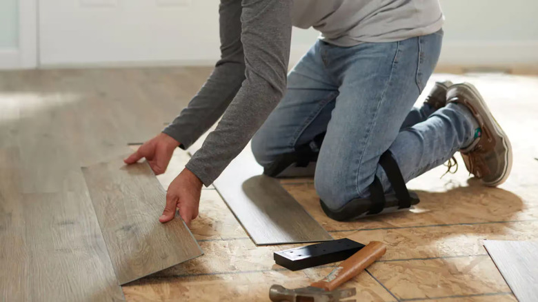 A person laying a laminate floor