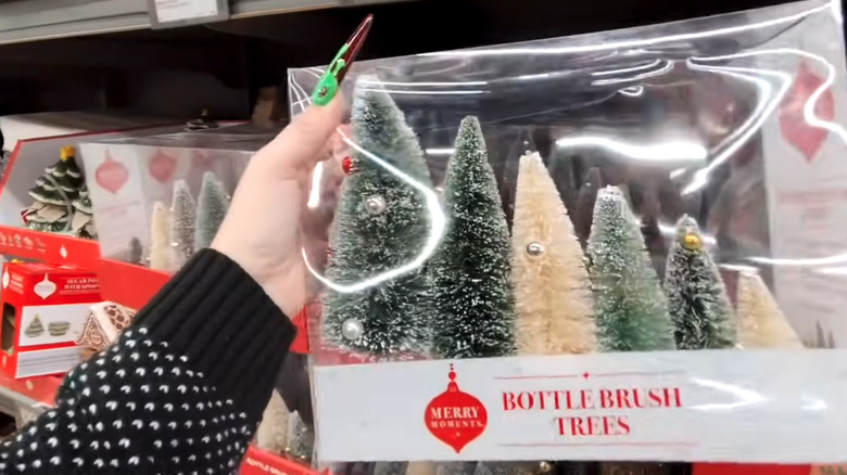 Someone holding Aldi's bottlebrush decorative Christmas tree set