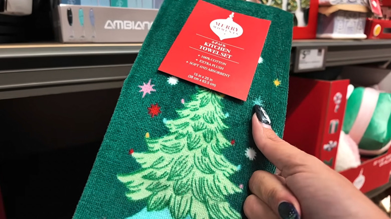 Two of Aldi's Christmas tree tea towels, one in emerald green, and the other in white and pink
