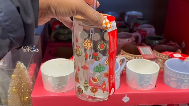 Someone holding one of Aldi's decorated glass drinkware