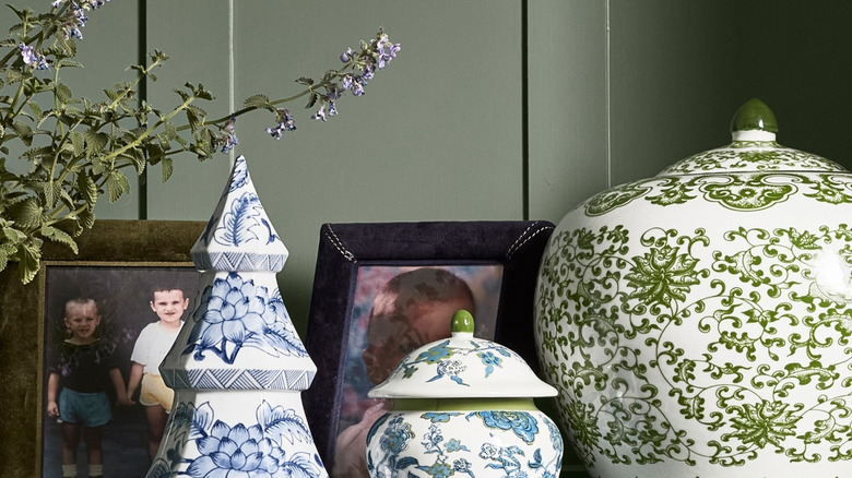 A blue and white Chinoiserie Ceramic Christmas Tree from Williams Sonoma sits in front of framed photos on a bookshelf
