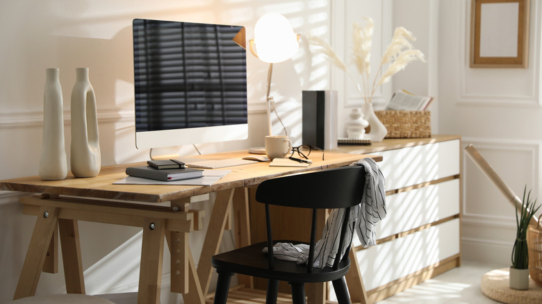 A home office with an iMac, a wooden desk, and a black chair.