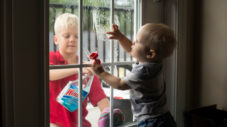 kids cleaning window with Windex