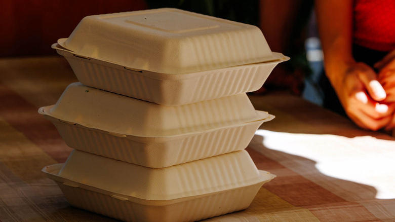 Stack of three takeout containers on a table